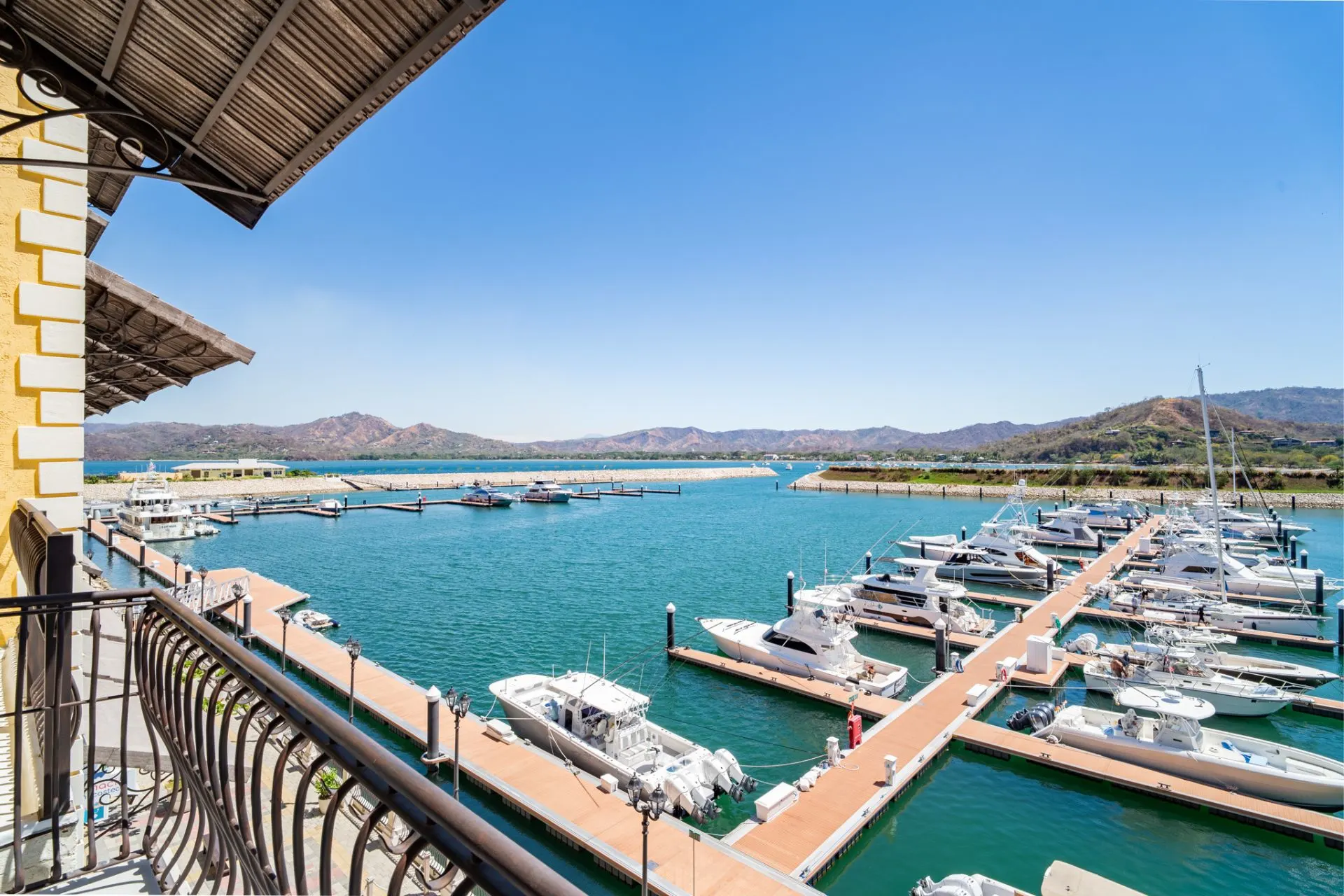 A balcony overlooking a marina with boats docked.
